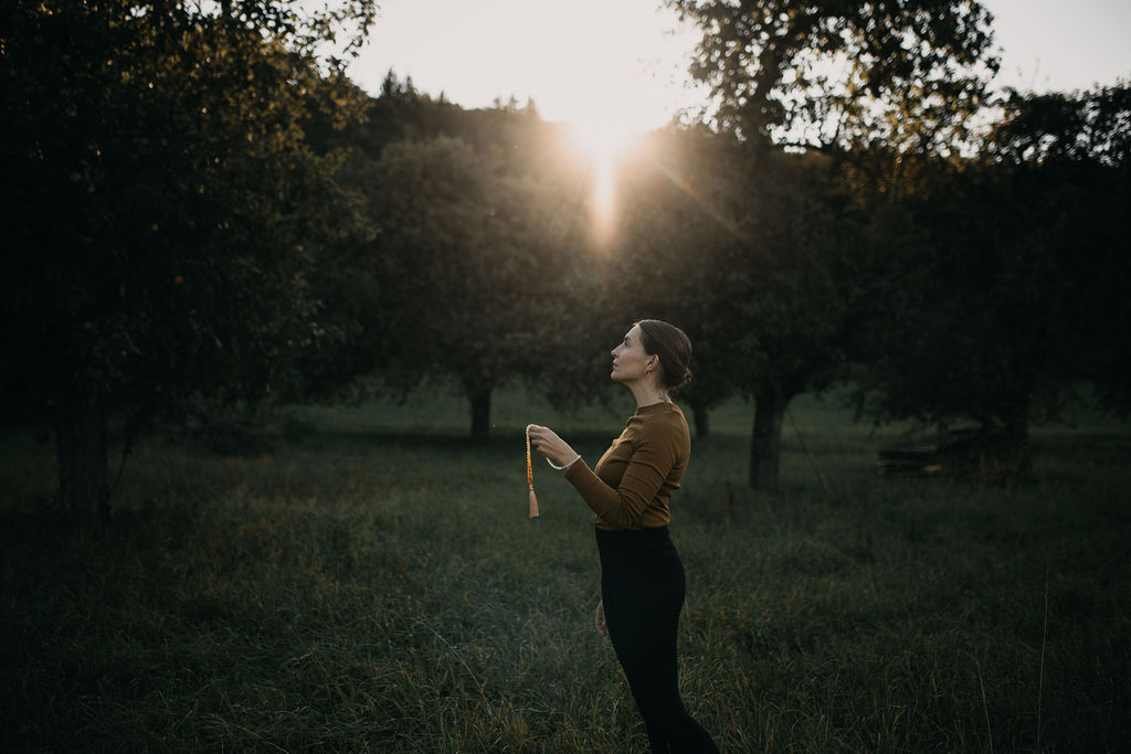 Frau steht ruhig in meditativer Haltung – Symbol für innere Sicherheit und Stabilität jenseits äußerer Kontrolle.