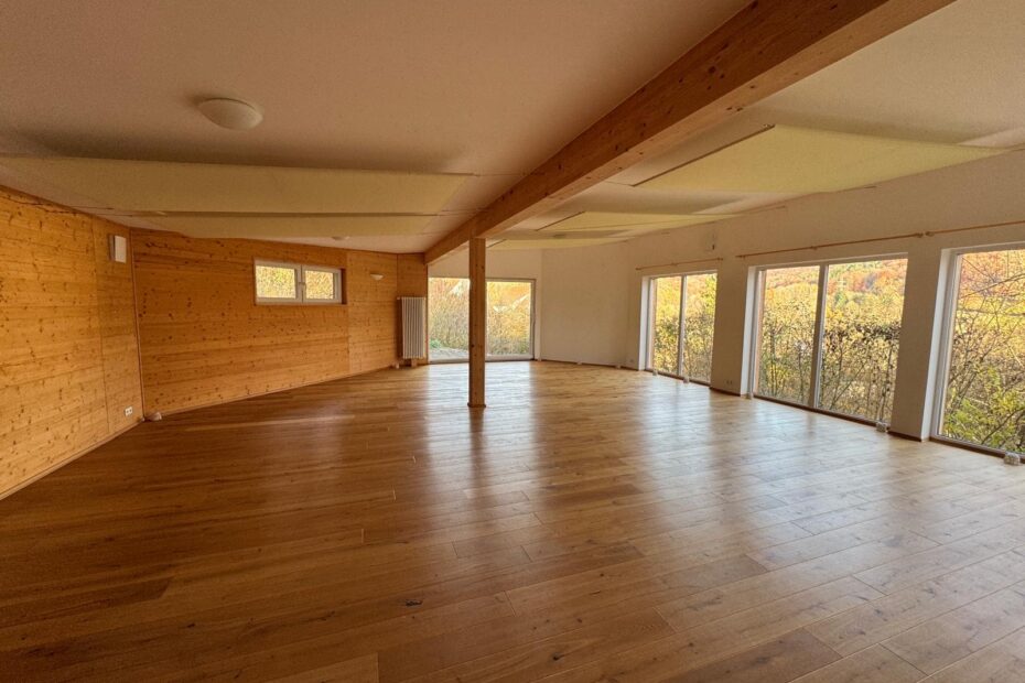 Weitläufiger und gemütlicher Yoga Raum mit Ausblick in die Natur