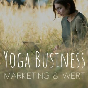 Yogalehrerin sitzt im Gras und arbeitet an einem laptop